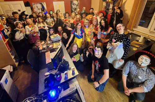 Uczestnicy imprezy karnawałowej w szkole języka włoskiego Porto Felice w Katowicach, przebrani w kolorowe stroje.